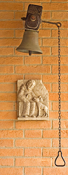 Cloche et haut-relief en pierre représentant saint François et le loup